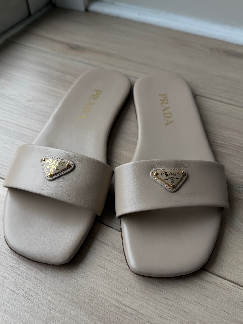 Prada Beige Slide Mules with Gold Triangle Logo